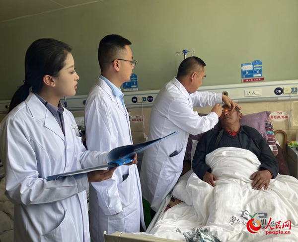 董光明（左三）帶領醫(yī)生對患者進行術前檢查。人民網記者 杜燕飛攝