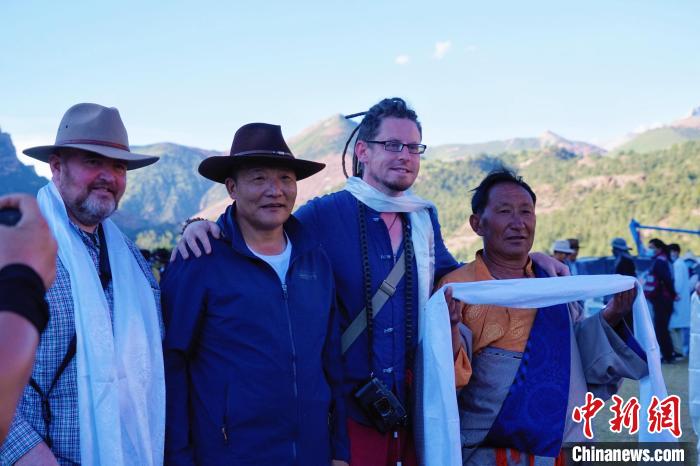 圖為當地民眾與外籍攝影師合影留念。　馬銘言 攝