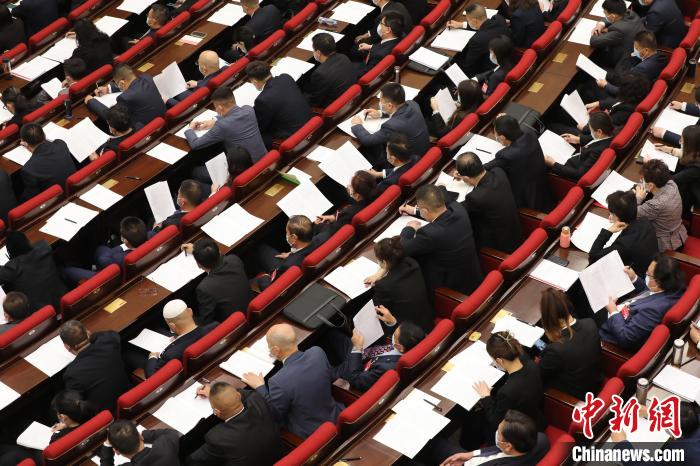 圖為會議現(xiàn)場，參會代表正在聽取政府工作報(bào)告?！∑钤鲚?攝