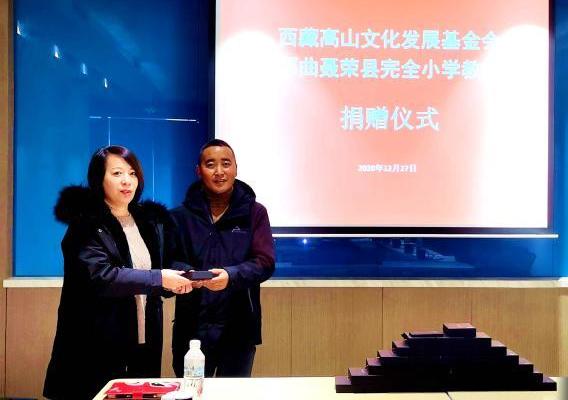 圖為西藏高山文化發(fā)展基金會(huì)理事長(zhǎng)溫麗向聶榮縣完全小學(xué)負(fù)責(zé)人捐助儀器?！∮谫e 攝