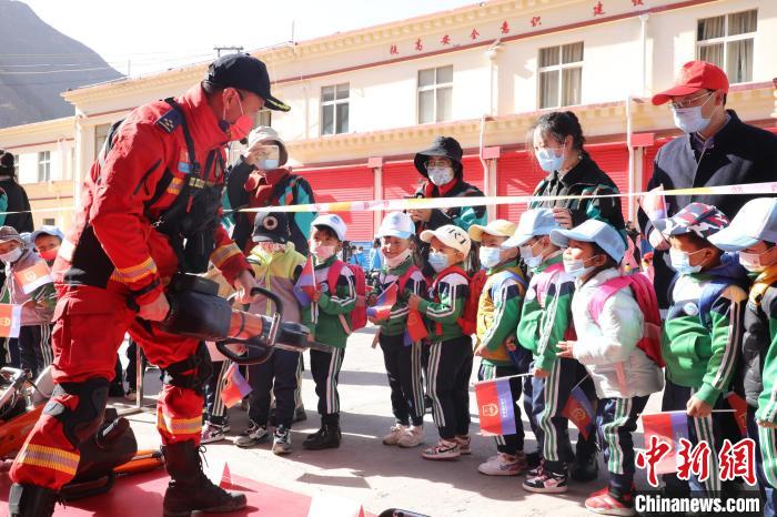 圖為消防指戰(zhàn)員為學(xué)生講解、演示先進救援裝備?！≮w琳 攝