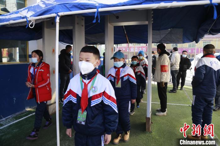 圖為學生測量體溫后進入校園?！●R銘言 攝