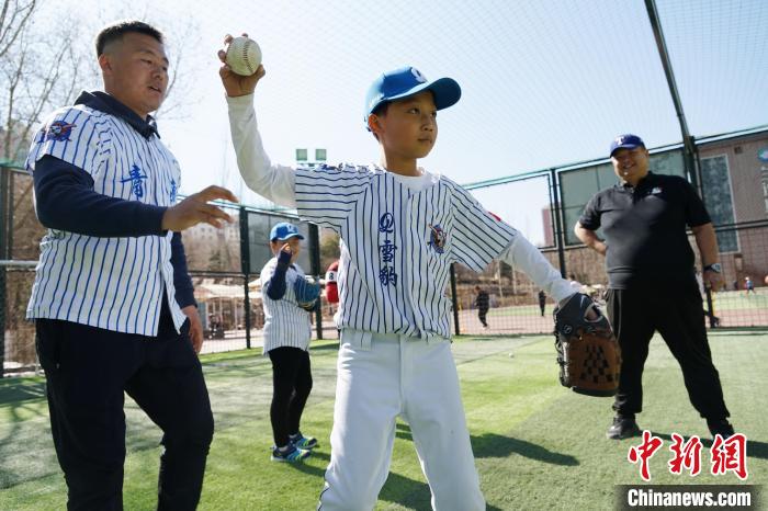 圖為教練指導小棒球手擲球技術?！●R銘言 攝