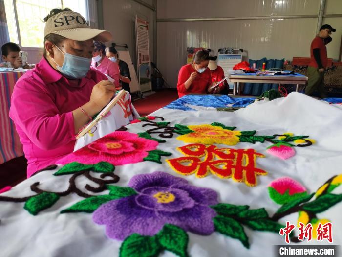 圖為婦女制作青繡?！?zhí)砀?攝