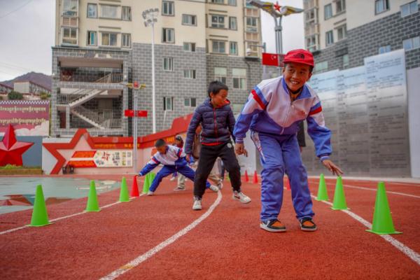 在高原上教孩子們打手球，“慢慢兒來，甭著急！”