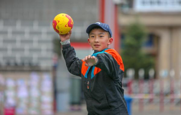 在高原上教孩子們打手球，“慢慢兒來，甭著急！”