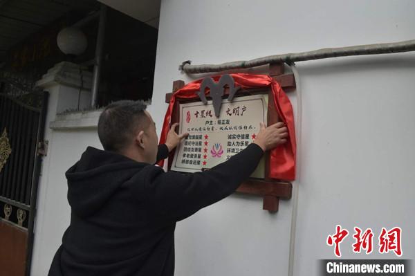 桂溪鎮(zhèn)渭溝村政府工作人員為“十星級(jí)文明戶”掛上牌匾?！钣?攝