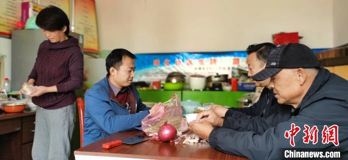 圖為扶貧路上“臨時(shí)一家人”準(zhǔn)備午餐?！∥航ㄜ?攝