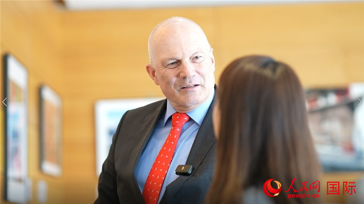 瑞士駐華大使白瑞誼介紹使館內(nèi)陳列的照片。人民網(wǎng) 彭昱凱攝