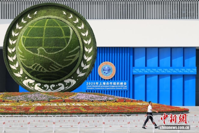 8月31日，天津，一名工作人員從2025年上海合作組織峰會主會場外的景觀花壇旁經(jīng)過。當日，2025年上海合作組織峰會在天津舉行。<a target='_blank' href='/'><p  align=