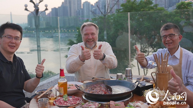 康寧顯示科技事業(yè)部全球拓建項目總監(jiān)軻寶華（中）和同事在重慶南濱路吃火鍋。人民網(wǎng)記者 蘇纓翔攝