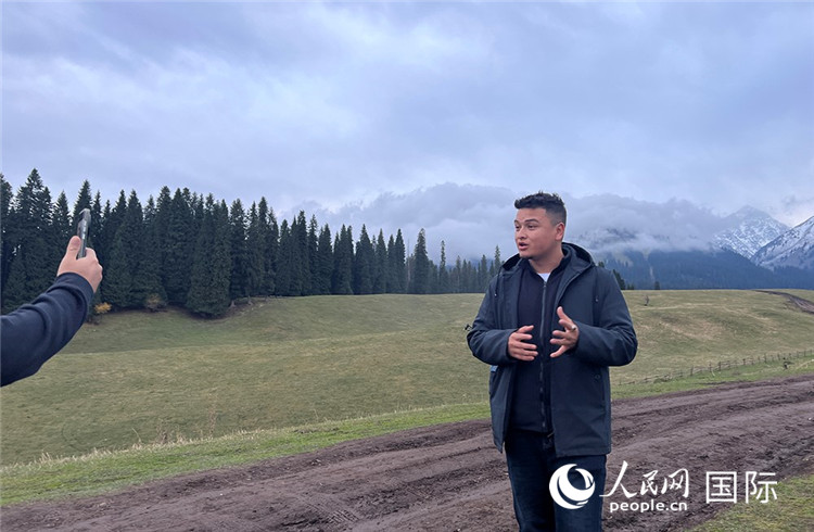 在庫(kù)爾德寧，吾買爾江被雪山美景震撼，即興錄制了短視頻作品。人民網(wǎng)記者曾書柔攝