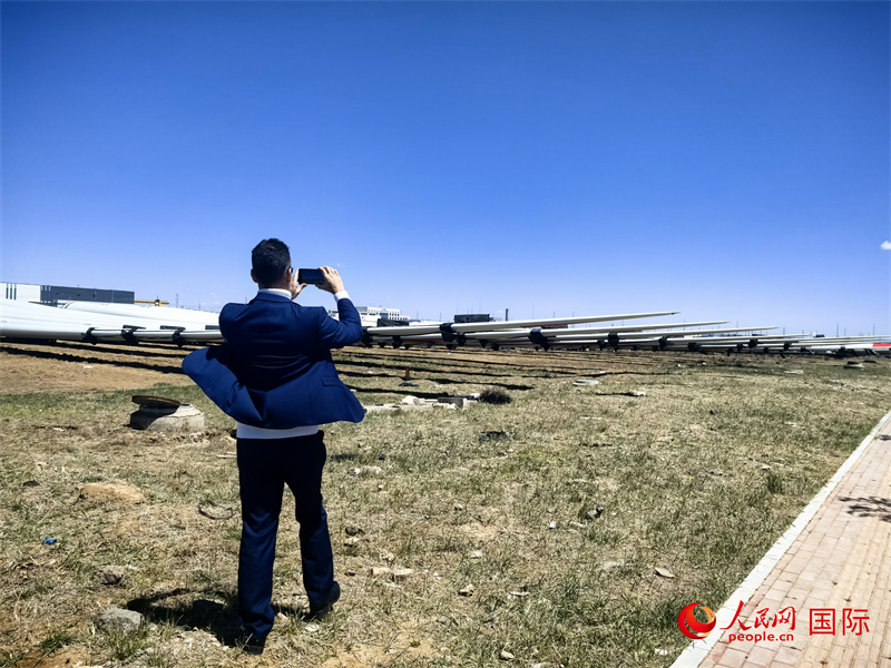 外媒記者拍攝廠房外的風(fēng)力渦輪發(fā)電機(jī)的巨型漿葉。人民網(wǎng) 楊春燕攝