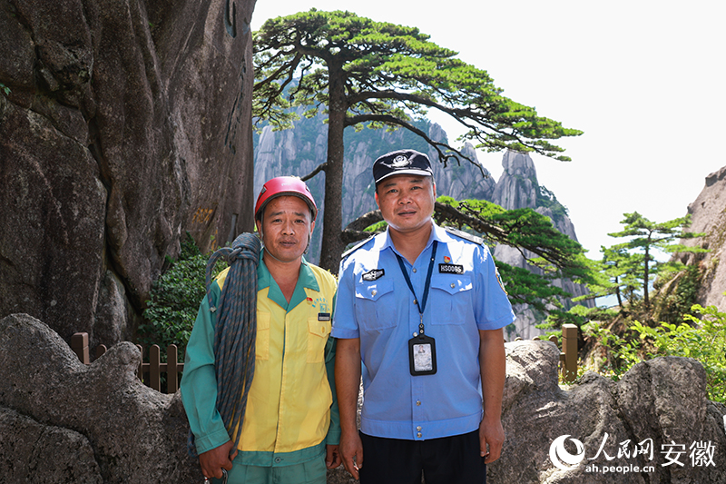 全國道德模范李培生（左）和胡曉春在迎客松前合影。人民網(wǎng)記者 張俊攝
