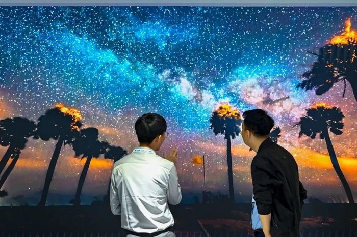 長(zhǎng)春光博會(huì)希達(dá)電子展區(qū)，一位工作人員正在給一位觀眾講解。（長(zhǎng)春新區(qū)供圖）