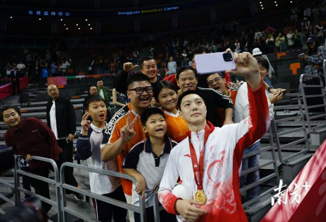 11月12日，十五運(yùn)會(huì)男籃成年組決賽，廣東隊(duì)獲得冠軍后，胡明軒與球迷們合影留念。張由瓊 攝