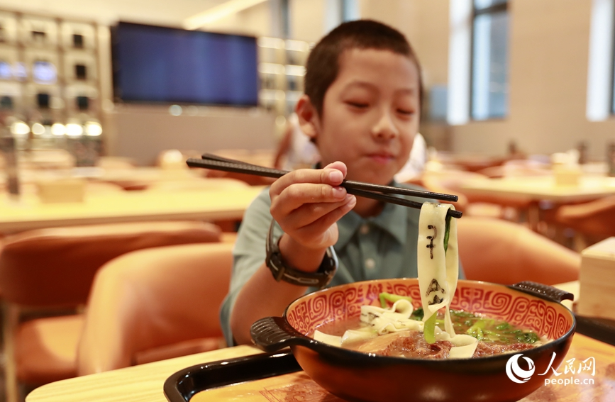 殷墟博物館推出的甲骨文面深受游客喜愛。人民網(wǎng)記者 慎志遠(yuǎn) 攝