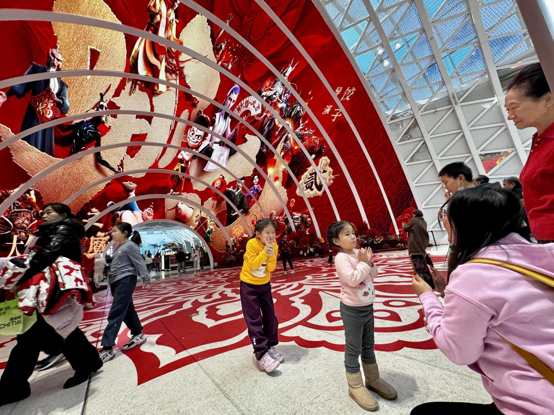 乙巳蛇年春節(jié)期間，影迷在《哪吒之魔童鬧海》巨幅海報前拍照打卡。