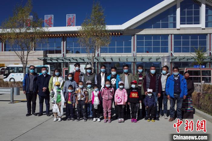 10位接受先心病治療的孩子及家長、工作人員等在日喀則和平機場合影?！〗w波 攝