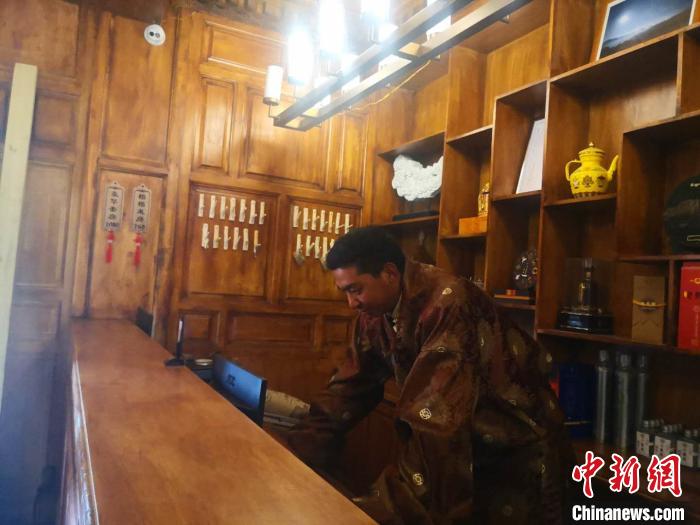 圖為桑杰才讓用電腦處理財務(wù)?！∈缝o靜 攝