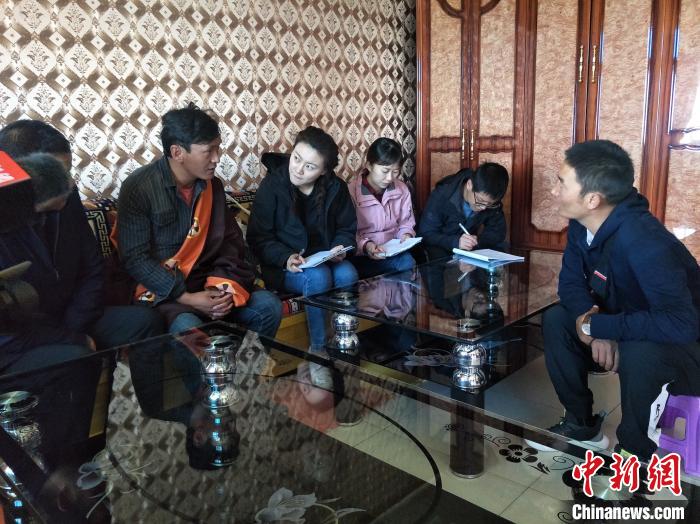 圖為調(diào)查組工作人員正在入戶調(diào)查。　祁增蓓 攝