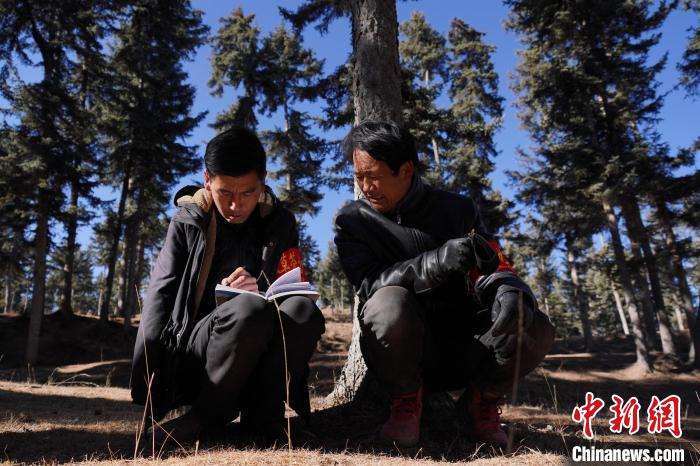 圖為桑杰加(左)和同事記錄巡查結(jié)果?！●R銘言 攝