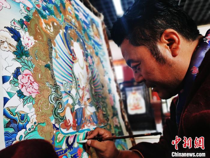 圖為久美尖措創(chuàng)作唐卡?！?zhí)砀?攝