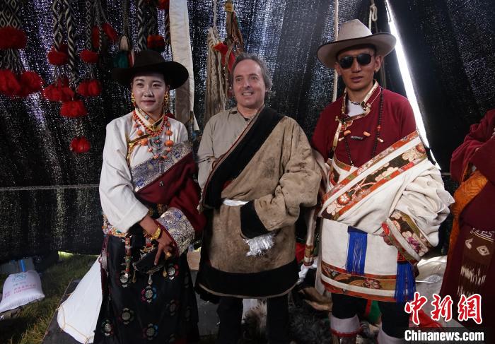 圖為一名外籍?dāng)z影師(中)身穿藏服和藏族民眾合影留念?！●R銘言 攝