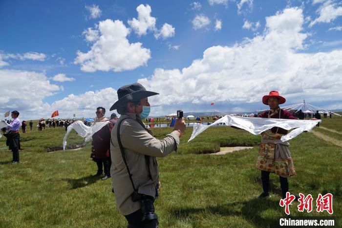 圖為一名外籍?dāng)z影師記錄當(dāng)?shù)夭刈鍤g迎儀式?！●R銘言 攝