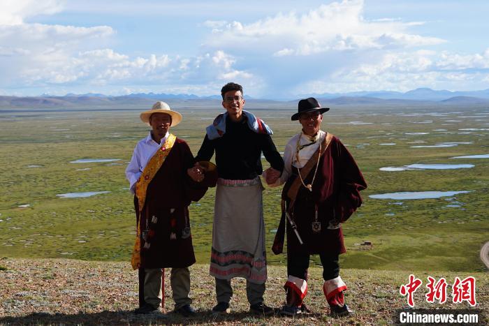 圖為一名留學(xué)生身穿自己國家的服飾和藏族民眾合影留念。　馬銘言 攝