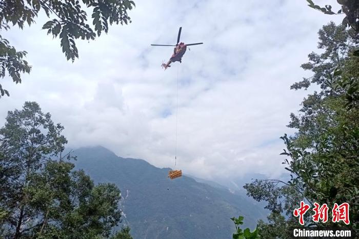直升機起飛將搶修塔材運往海拔1950米的110千伏唐下線29號塔位。　徐慶明 攝