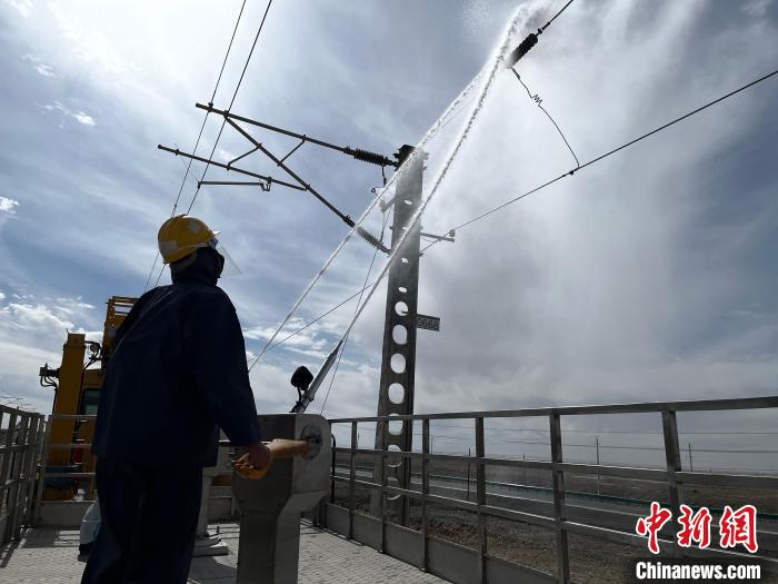 圖為高壓水槍的水柱沖洗絕緣子串?！「邌⒑?攝
