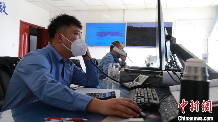 圖為貨運(yùn)調(diào)度人員與外勤工作人員聯(lián)系掌握車輛裝載情況?！±钌?攝