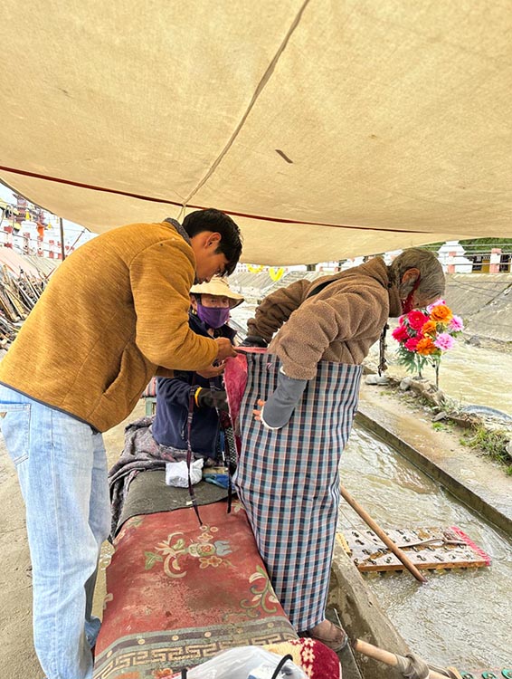 扎西奪爾登為路邊老人送去保暖圍腰。阿壩州文明辦供圖