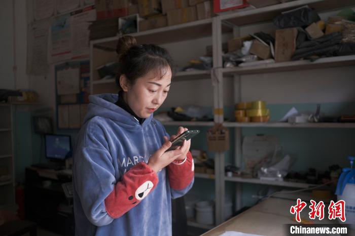 正在快遞站點(diǎn)內(nèi)忙碌的楊莉春?！『闻罾?攝