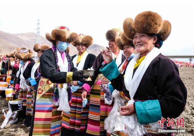 資料圖：西藏自治區(qū)拉薩市曲水縣才納鄉(xiāng)協(xié)榮村參加春耕儀式的村民互敬青稞酒。按照傳統(tǒng)，當(dāng)?shù)卮迕裆碇?jié)日盛裝，舉行隆重的儀式，祈福一年的豐收。<a target='_blank' ><p  align=