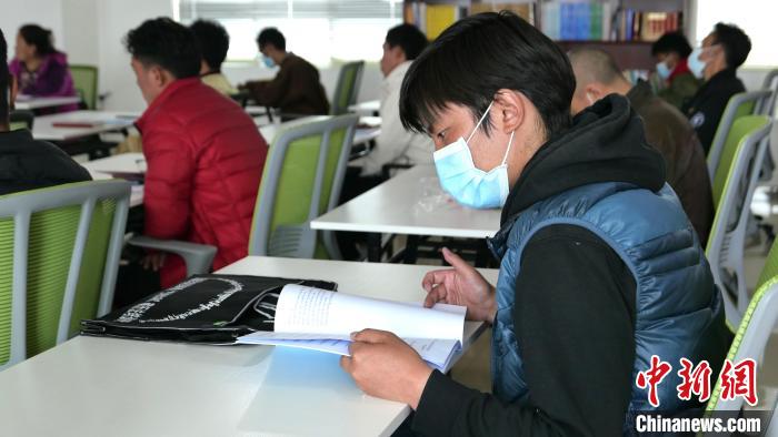 圖為正在閱讀“杰松達(dá)孜”藏歷法教材的學(xué)員?！≈x牧 攝