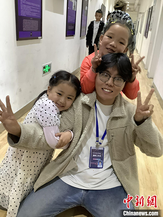 “Z世代”旦真旺加認(rèn)為，拉薩是一座開放與包容的城市，記憶中的拉薩是彩色的。2021年，旦真旺加從浙江大學(xué)漢語(yǔ)言文學(xué)專業(yè)畢業(yè)后，他選擇回到拉薩，成為一名漢語(yǔ)文實(shí)習(xí)助教。圖為8月4日，旦真旺加在課間陪學(xué)生玩耍。 <a target='_blank' ><p  align=