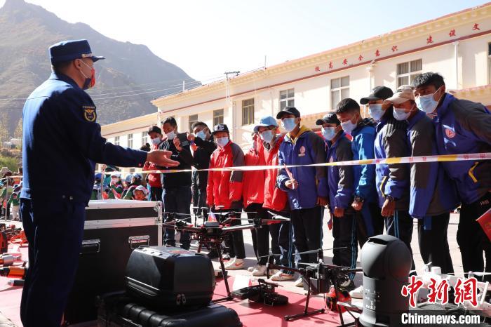 圖為消防指戰(zhàn)員為學(xué)生講解、演示先進(jìn)救援裝備?！≮w琳 攝