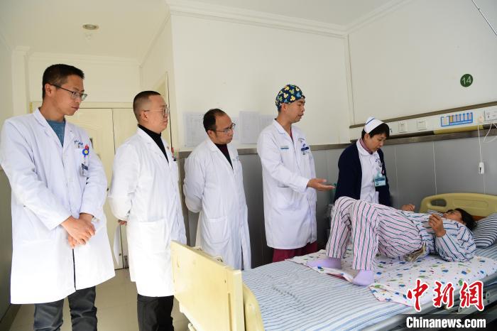 圖為何蔚副主任醫(yī)師(站右二)及團隊術(shù)后指導(dǎo)患者進行腰背肌鍛煉?！∝暩聛硭?攝