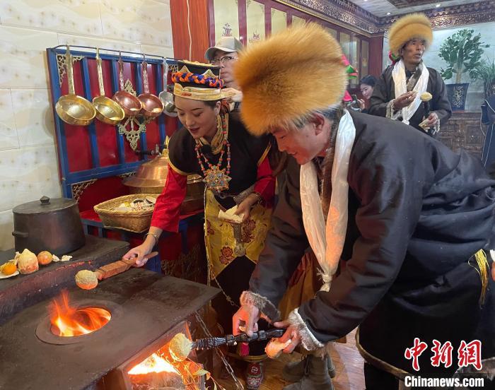 圖為人們?cè)诨鹕峡竟?jié)日美食“結(jié)達(dá)”。　冉文娟 攝