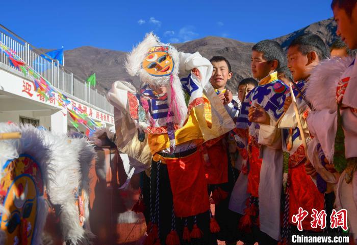 圖為加查縣安繞鎮(zhèn)小學(xué)學(xué)生在試穿藏戲面具?！∝暩聛硭?攝