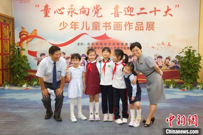 圖為與會嘉賓與入選畫作的“小作者”們在展覽上合影?！≈袊貙W研究中心供圖