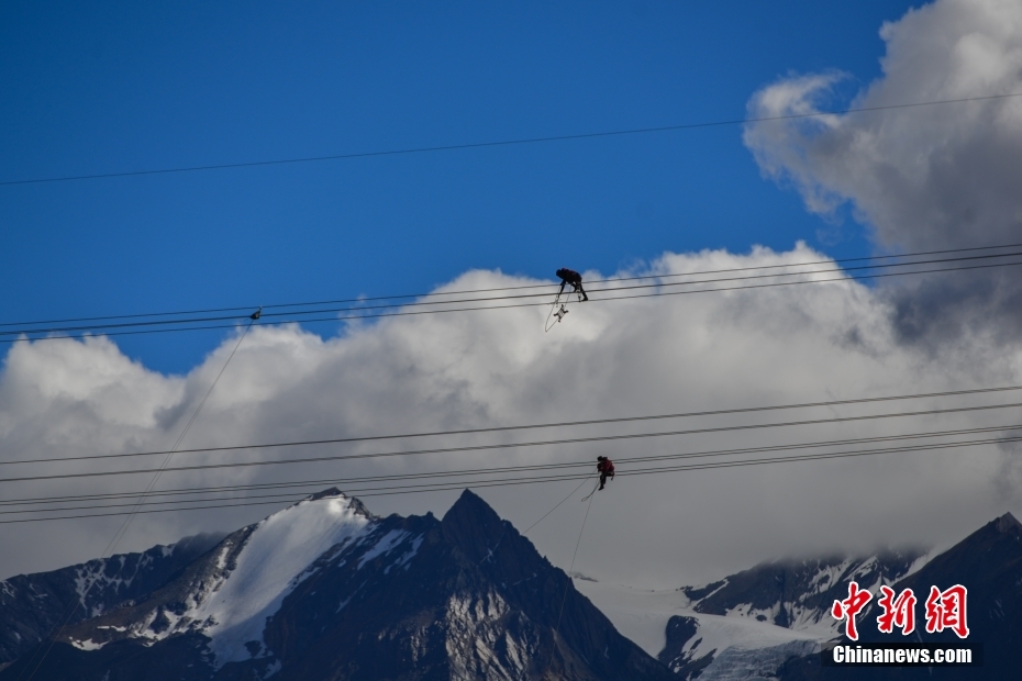 資料圖為2020年6月23日，西藏阿里聯(lián)網(wǎng)工程施工人員在日喀則希夏邦馬雪山附近進行走線作業(yè)，安裝絕緣設(shè)備。 <a target='_blank' href='/'><p  align=