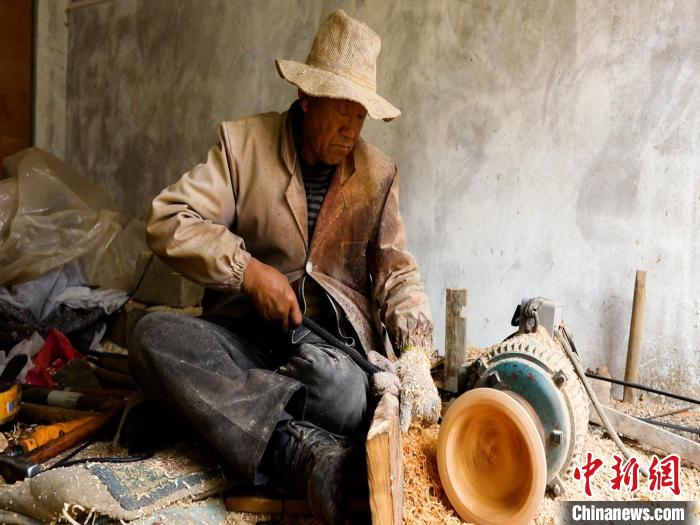 圖為手工藝人正在制作木碗。　 鄧海平 攝