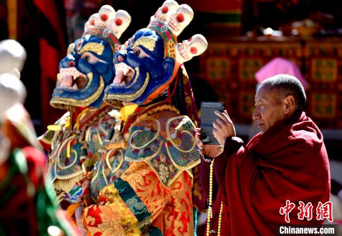 2月19日，正在拍攝跳神活動(dòng)的僧人。　李林 攝