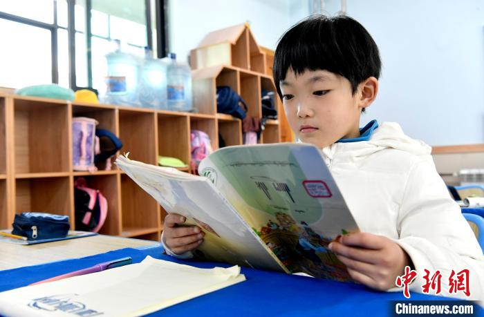 3月14日，西藏拉薩市第一小學一年級六班學生丁增樂吉在閱讀藏語課本。　李林 攝