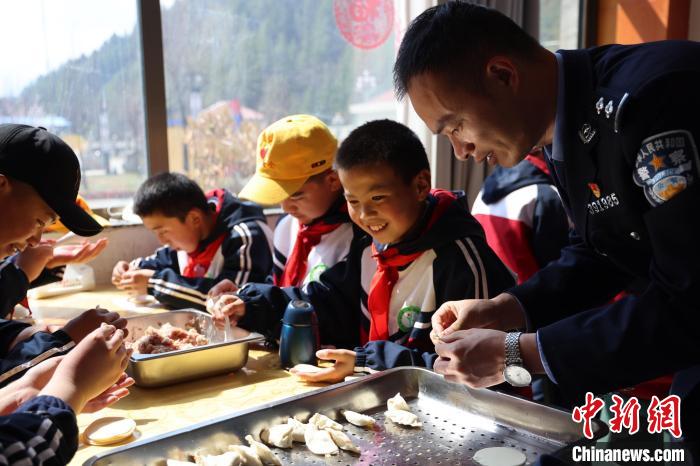 圖為亞東邊檢站民警與駐地小學(xué)生其樂融融包餃子。　胡利媛 攝