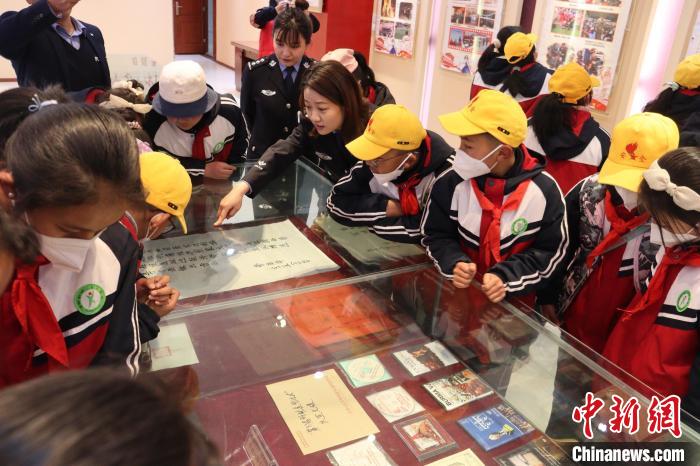 圖為亞東邊檢站民警為駐地小學(xué)生講解該站榮譽發(fā)展史。　胡利媛 攝