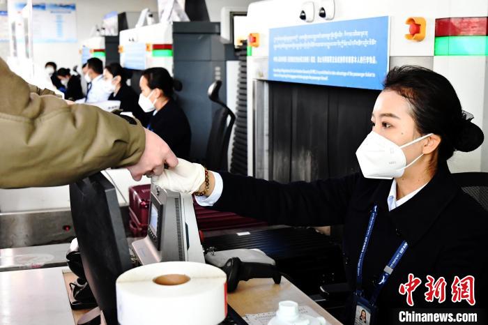 圖為機場工作人員為旅客辦理行李托運。　周航 攝